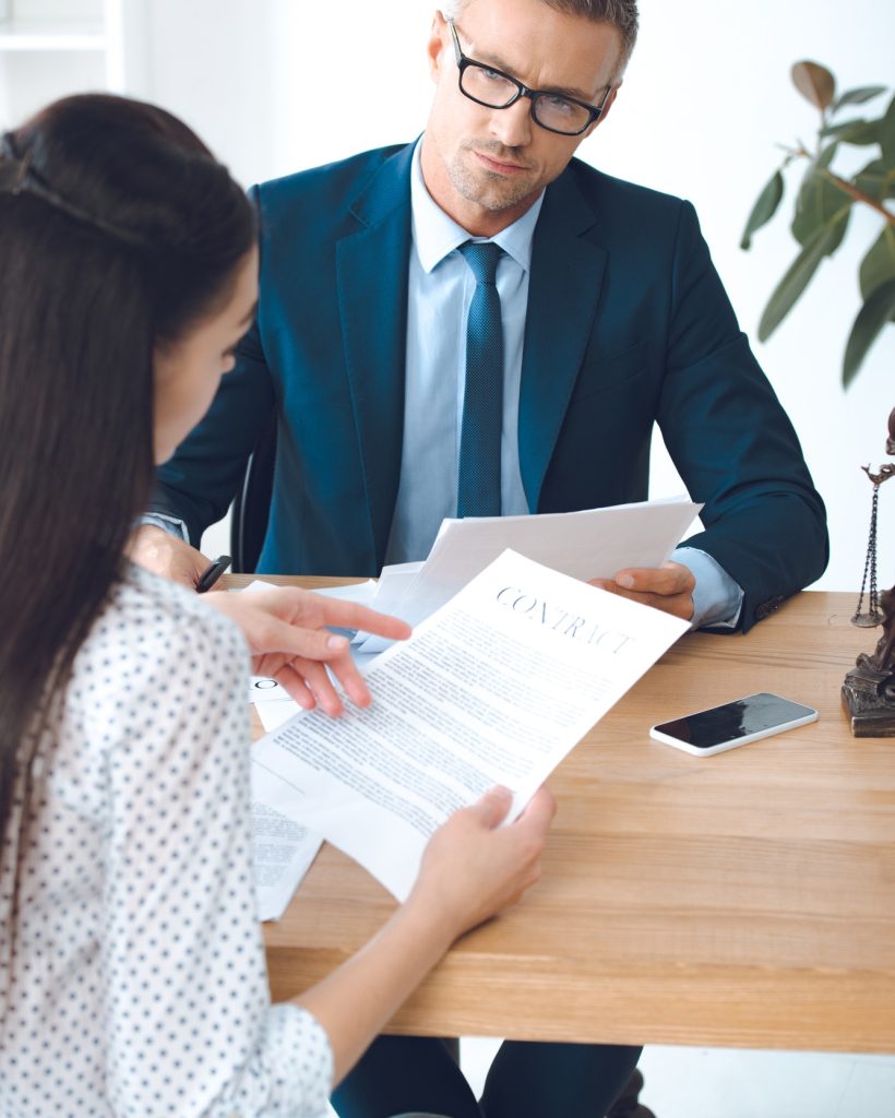 male-lawyer-looking-at-client-reading-contract.jpg